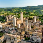 Aerial view of famous medieval San Gimignano hill town with its skyline of medieval towers, including the stone Torre Grossa. UNESCO World Heritage Site.